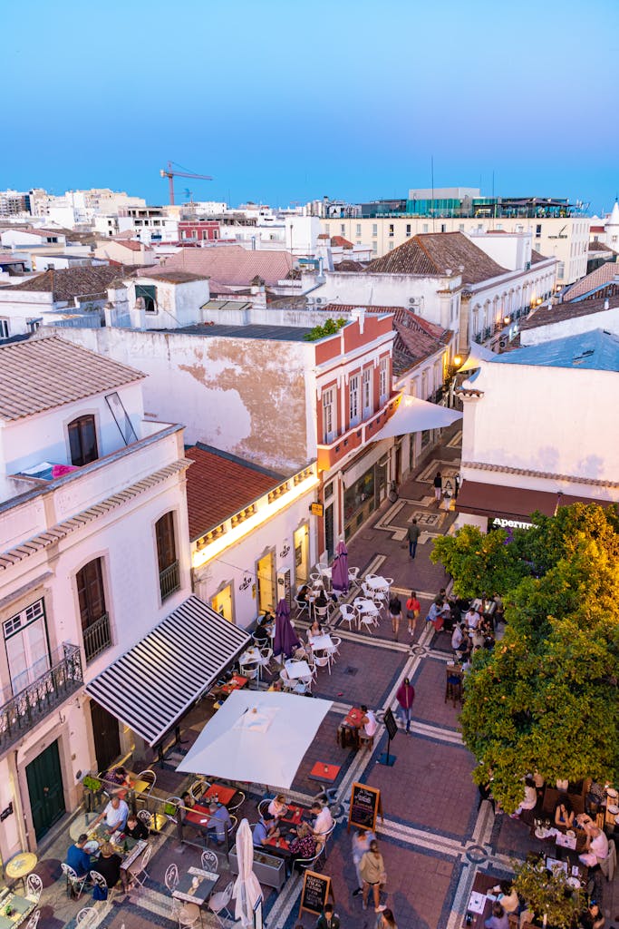 A lively evening scene in Faro, Portugal featuring bustling streets and outdoor cafes.
