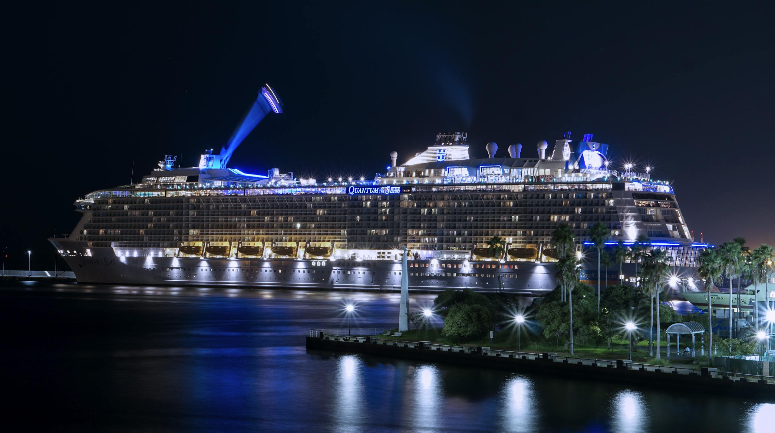 A stunning view of a cruise ship illuminated and docked at night in Fukuoka harbor.