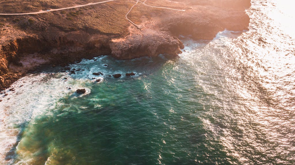 Breathtaking aerial shot of the rocky coastline in Faro District, Portugal during daytime.