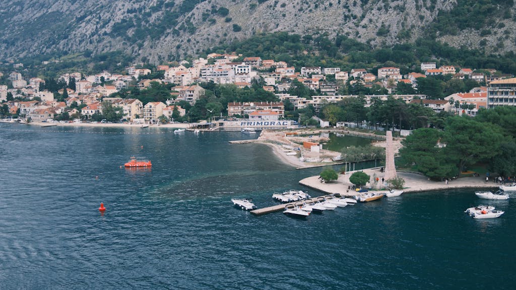 Scenic aerial view of a coastal town with marina and mountains in the background